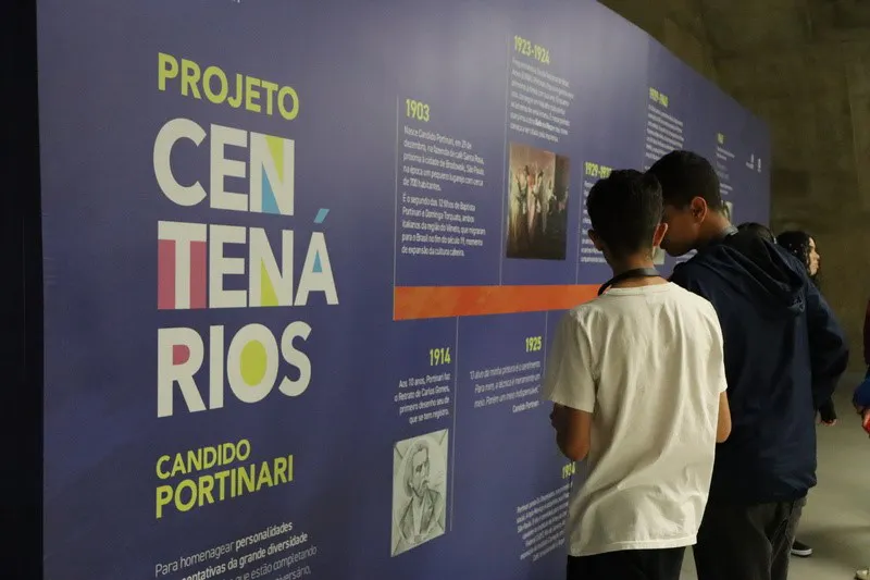 Visitantes observam painel do Projeto Centenários de Cândido Portinari com informações sobre a vida e obra do artista.