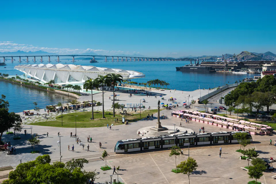 Vista aérea da Praça Mauá, no Rio de Janeiro, com o Museu do Amanhã em destaque e o VLT passando em primeiro plano.
