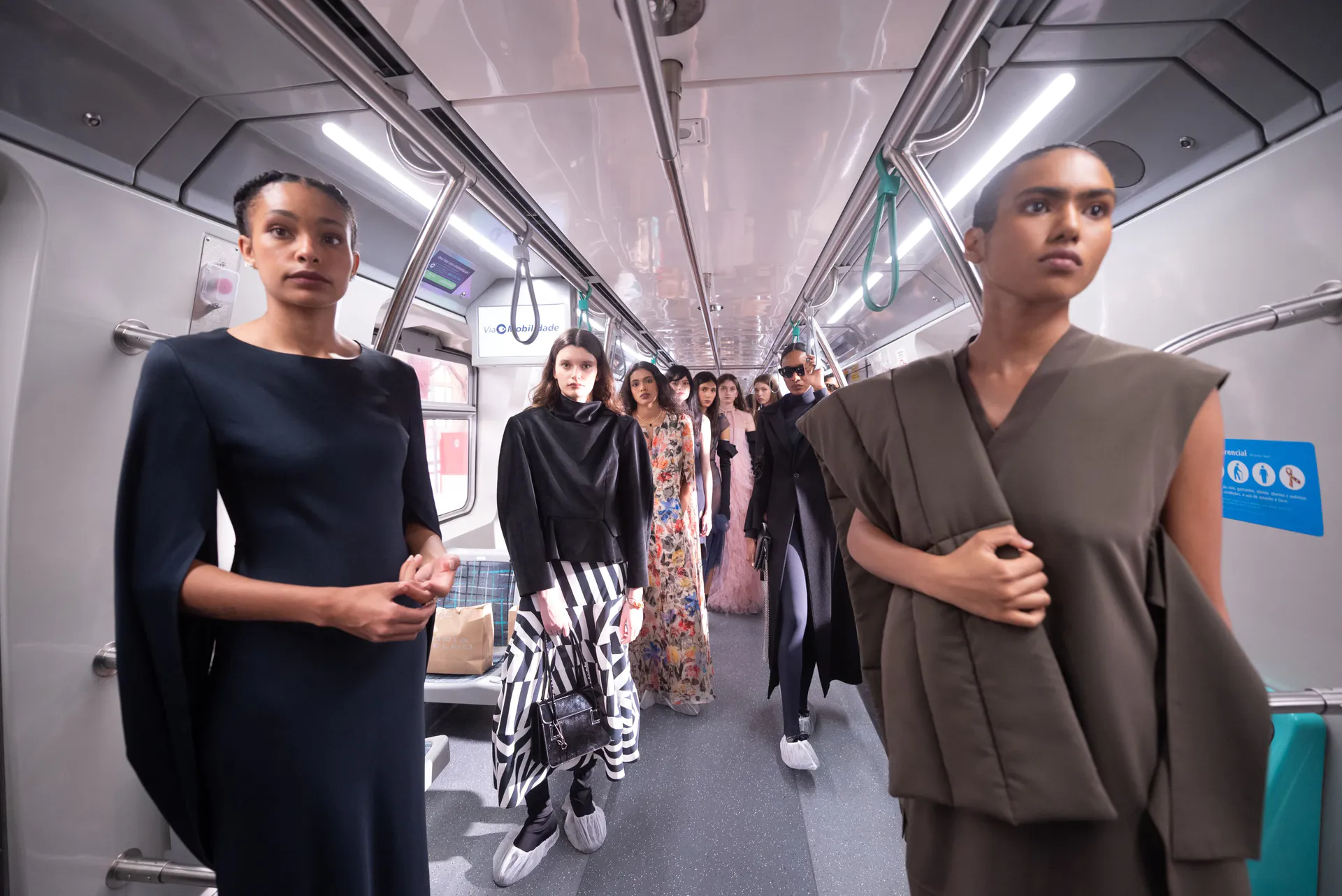 A imagem mostra um desfile de moda da estilista Glória Coelho dentro de um trem na Estação Júlio Prestes, em São Paulo.