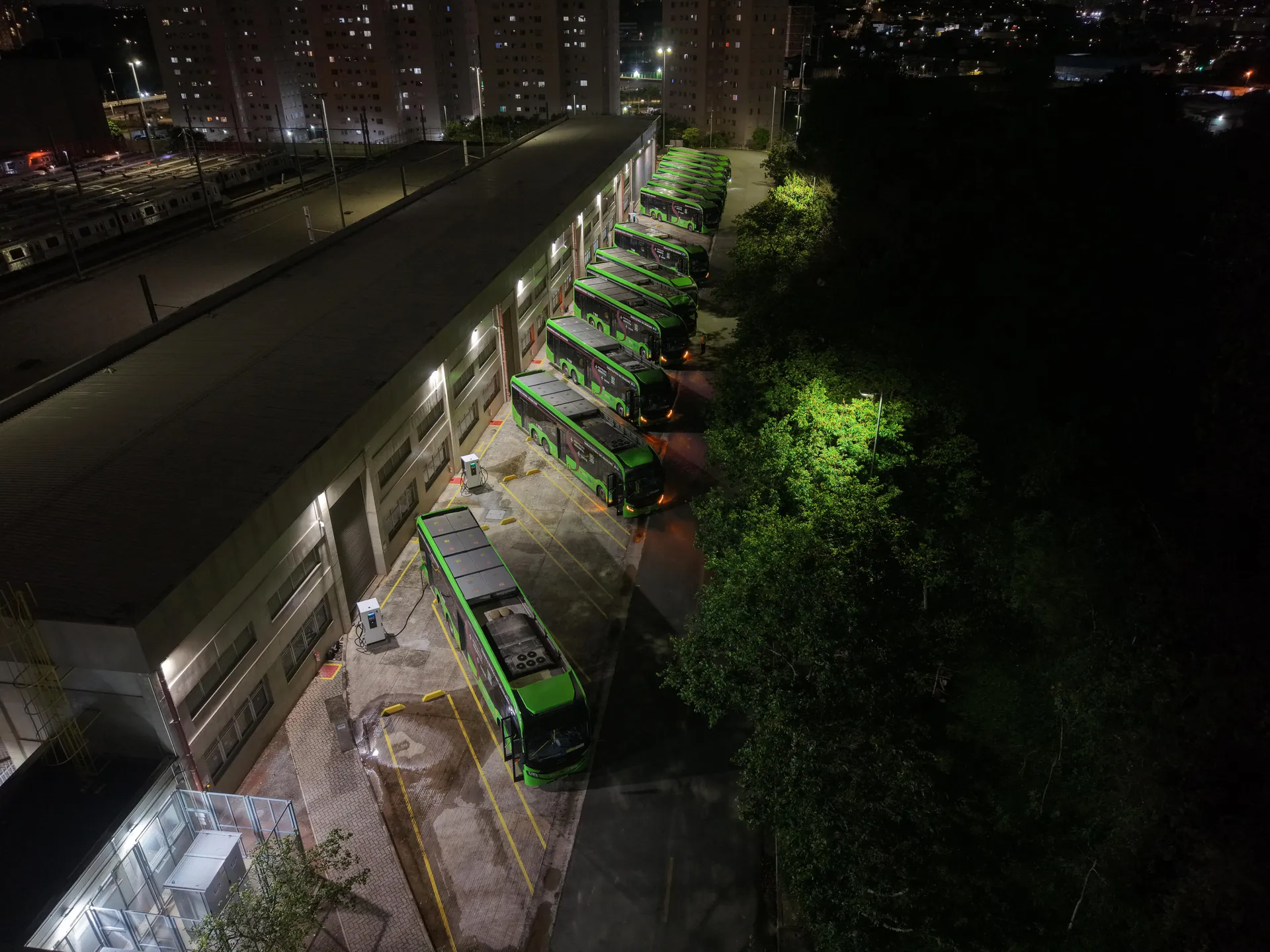 Ônibus elétricos verdes em fila recarregando à noite no Pátio Guido Caloi, em São Paulo