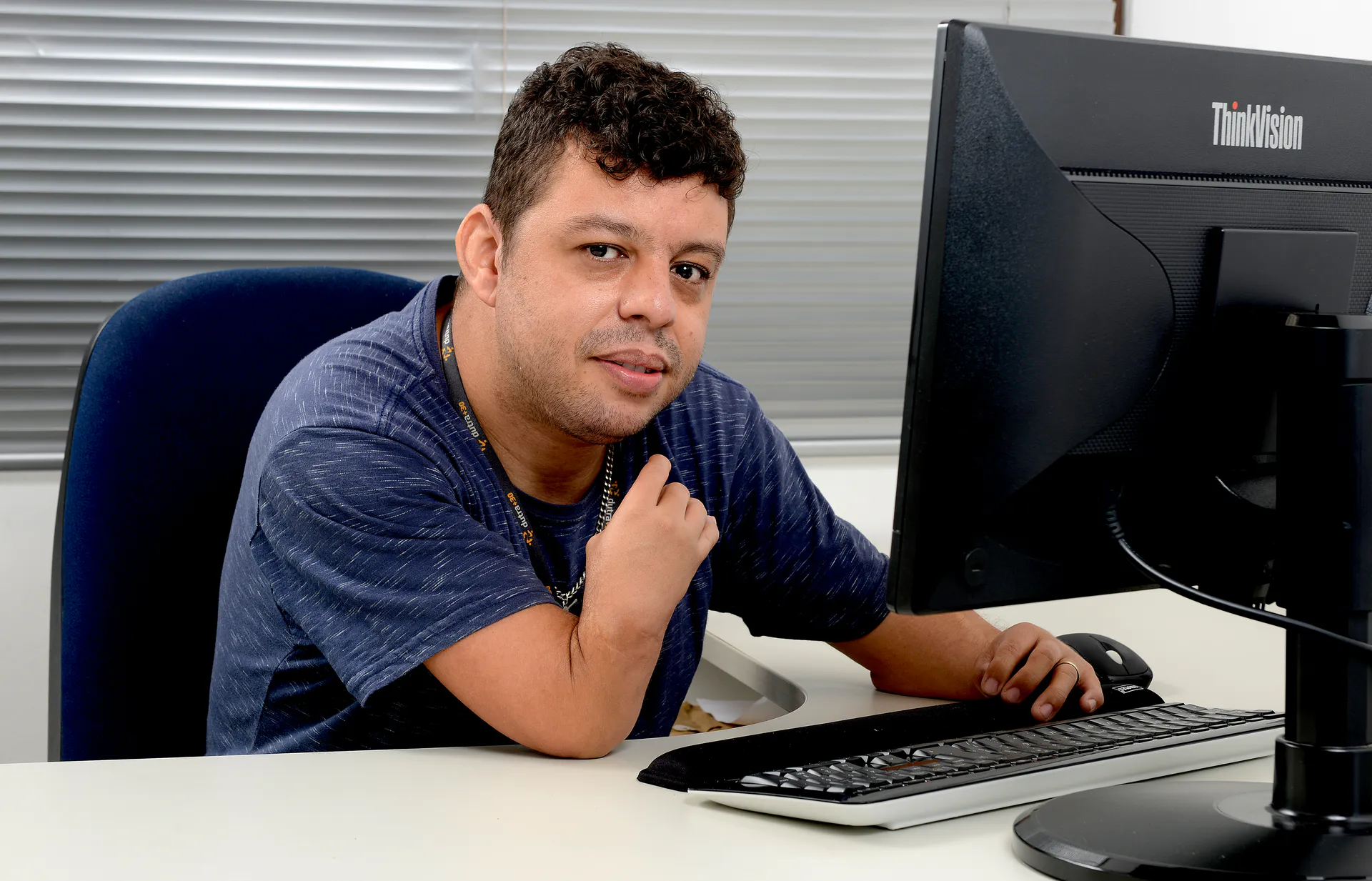 Imagem de perfil de um homem sentado em frente à um computador